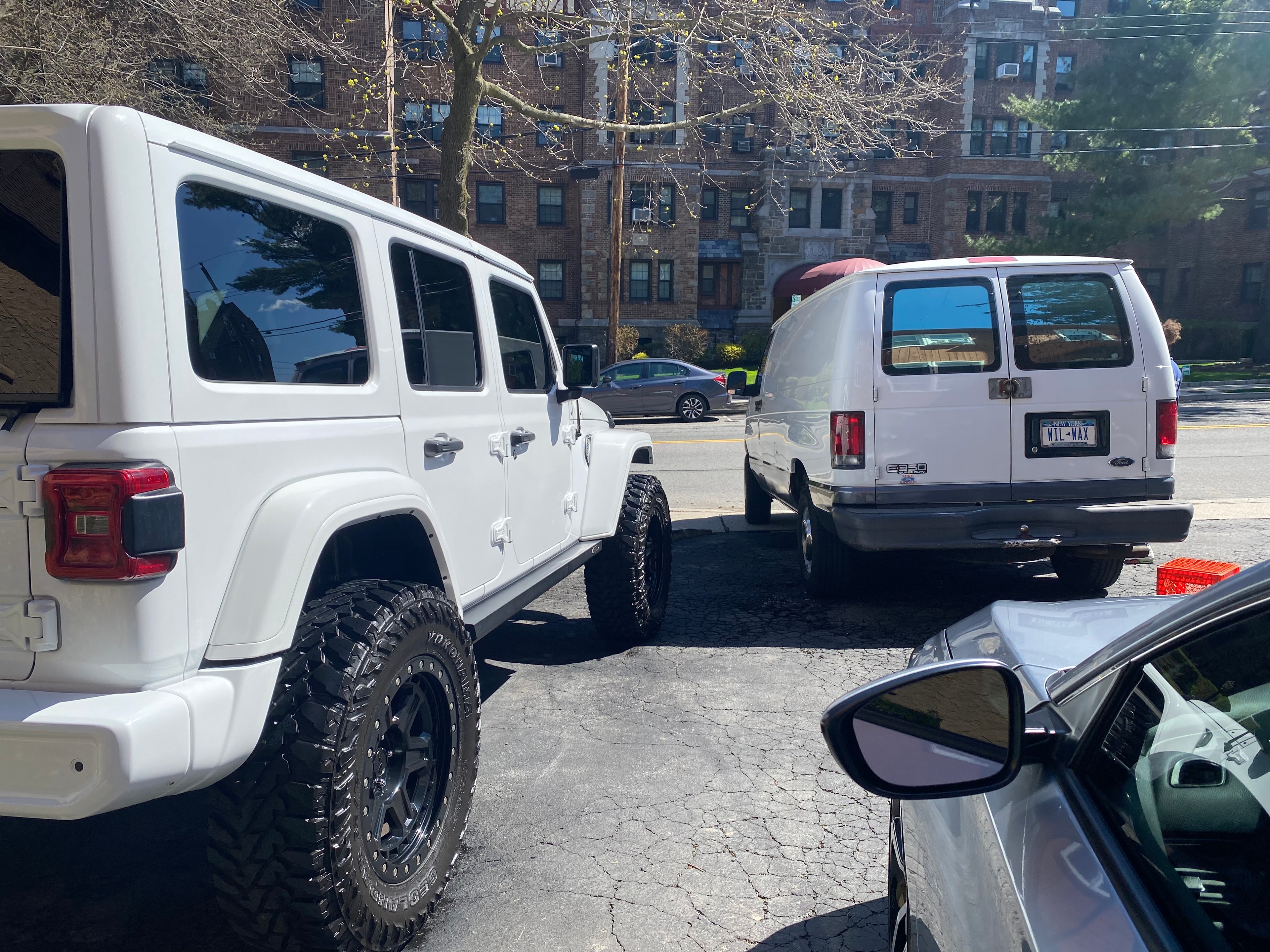 White Jeep Wrangler and Wilson Waxes van on a Bronxville street