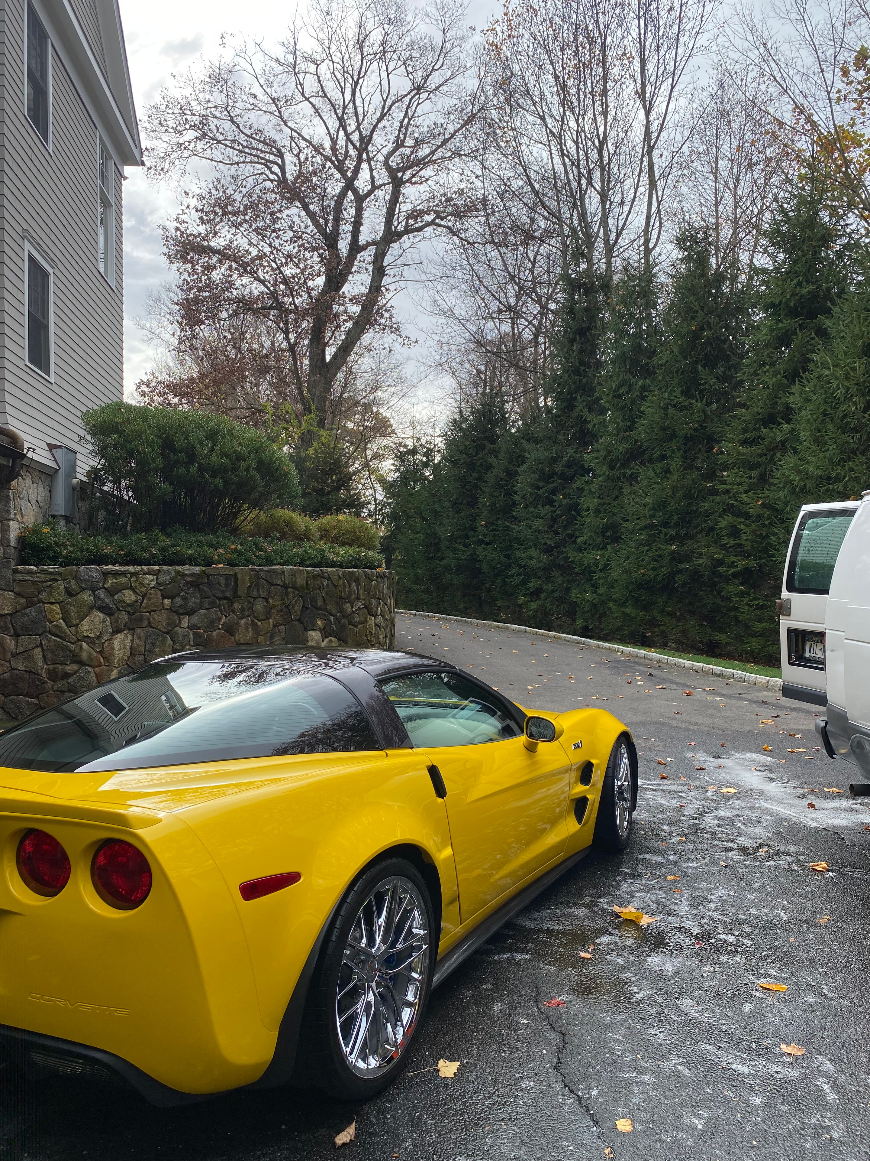 Yellow Corvette freshly detailed on a wet street in autumn
