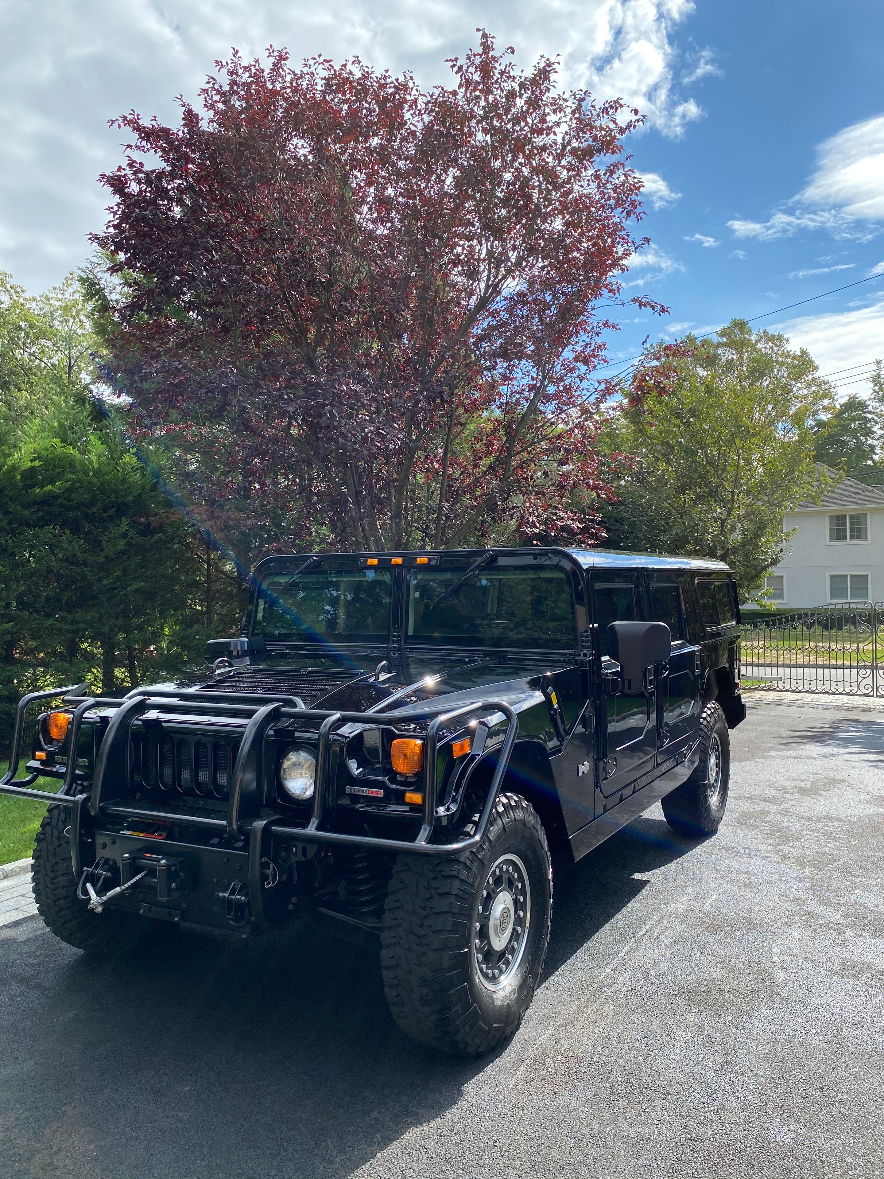 Black Hummer H2 freshly detailed on a Westchester street with autumn foliage