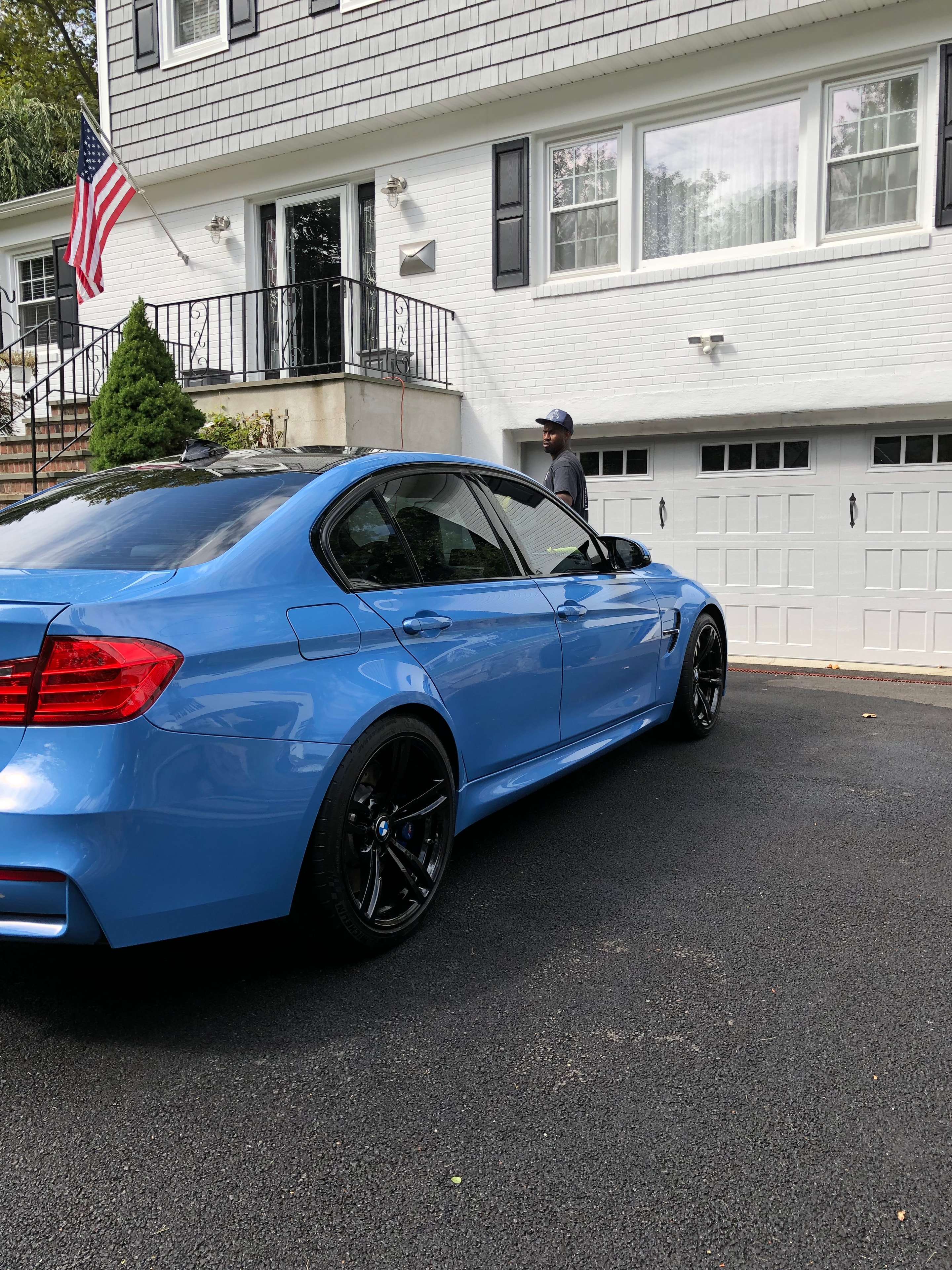 Blue BMW sedan freshly detailed in a residential driveway