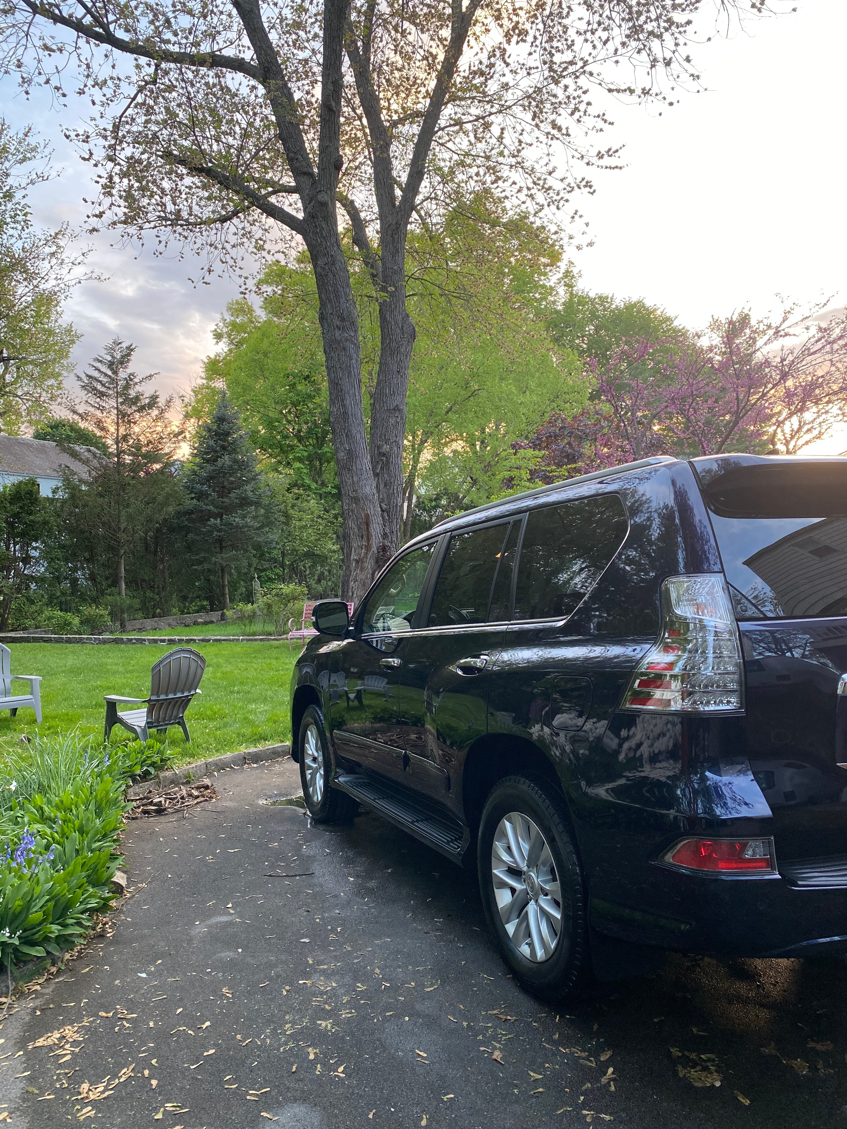 Black SUV detailed in a residential driveway at dusk