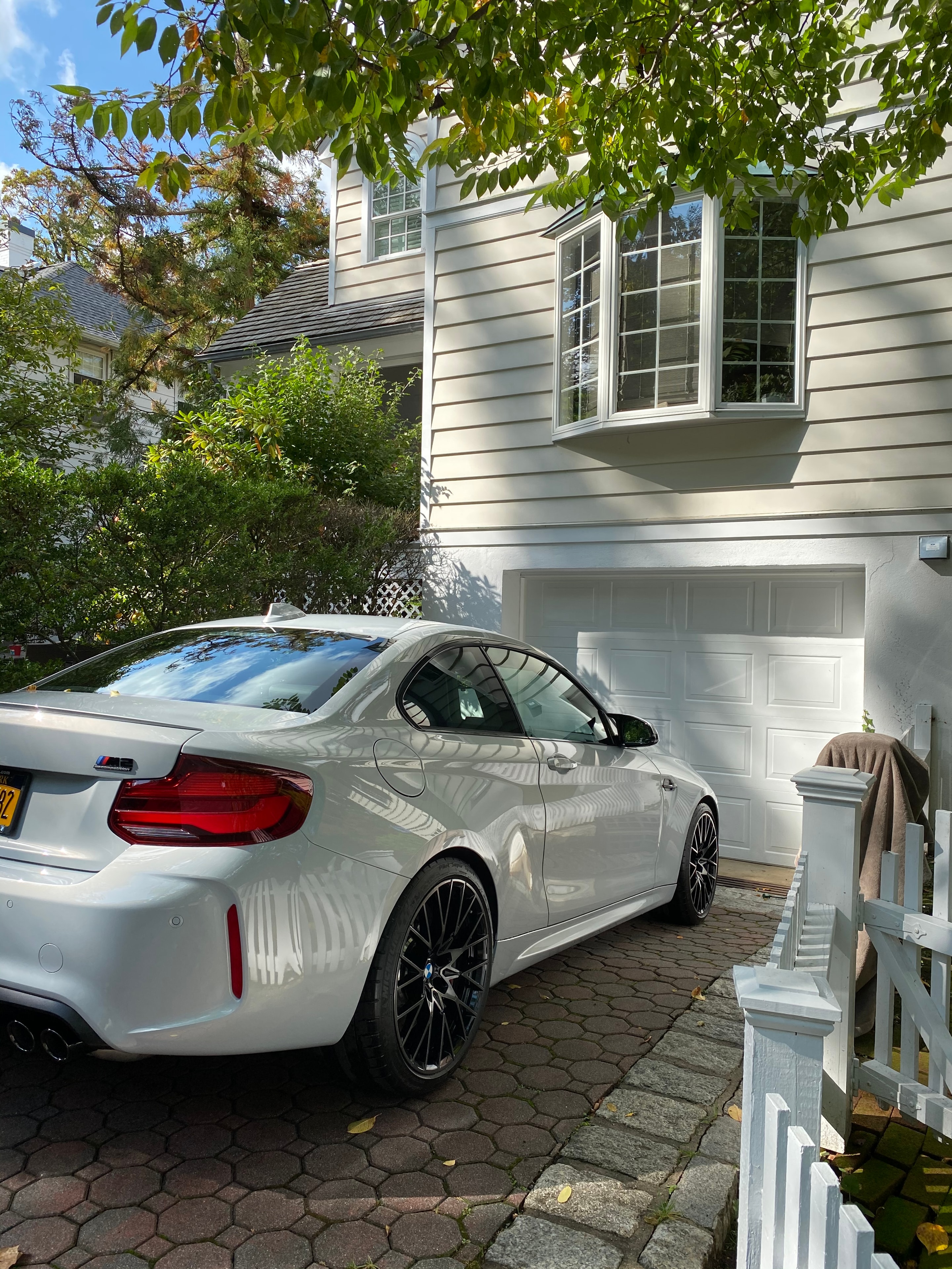 White electric vehicle detailed in a cobblestone driveway